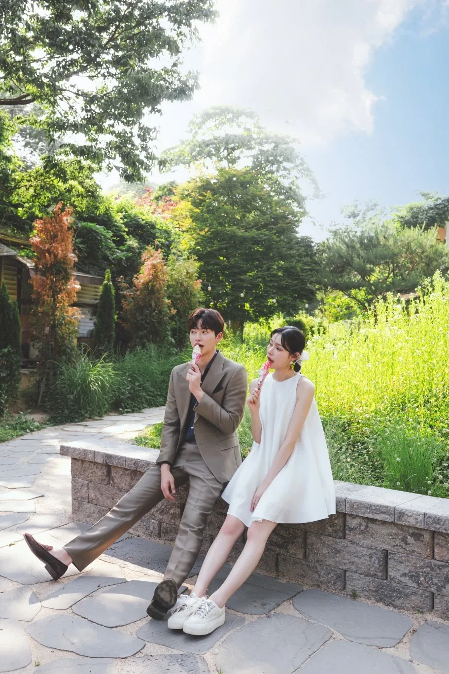 garden stone wall의 계절감과 동선을 살린 라이프스타일 커플 컷입니다. 자연스러운 움직임과 초록 배경을 원하는 커플에게 어울립니다.