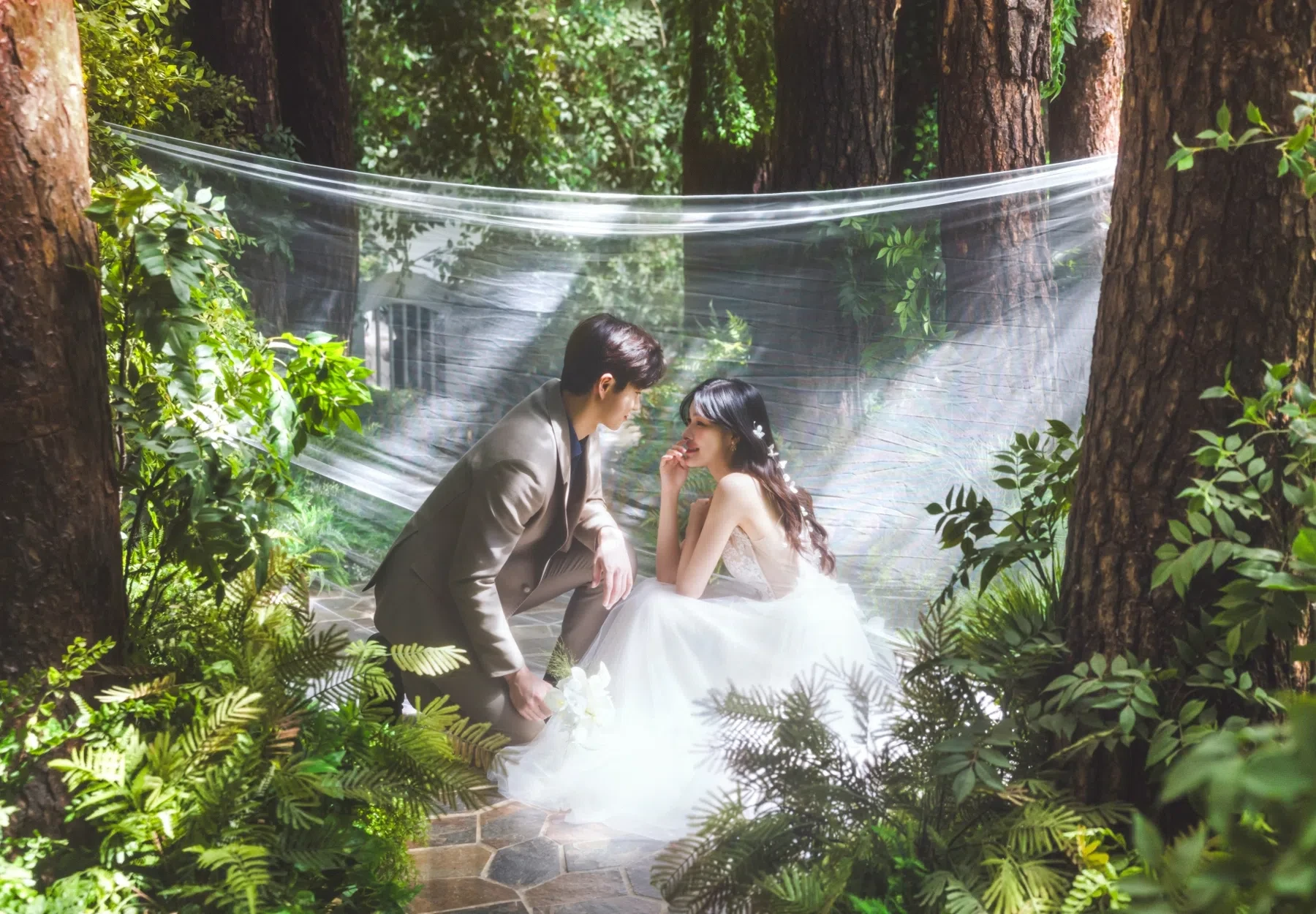 forest set의 계절감과 동선을 살린 포즈 중심 커플 컷입니다. 자연스러운 움직임과 초록 배경을 원하는 커플에게 어울립니다.