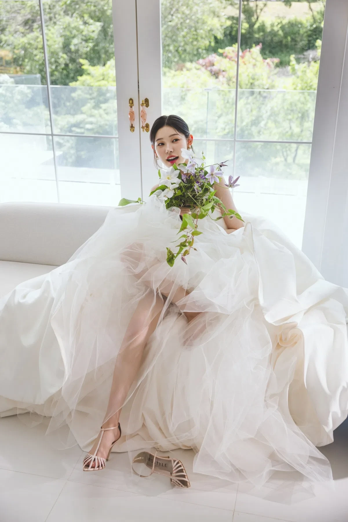 white window sofa의 자연광과 여백을 살린 신부 단독 포트레이트입니다. 의상 실루엣과 표정 중심의 깨끗한 무드를 확인하기 좋습니다.