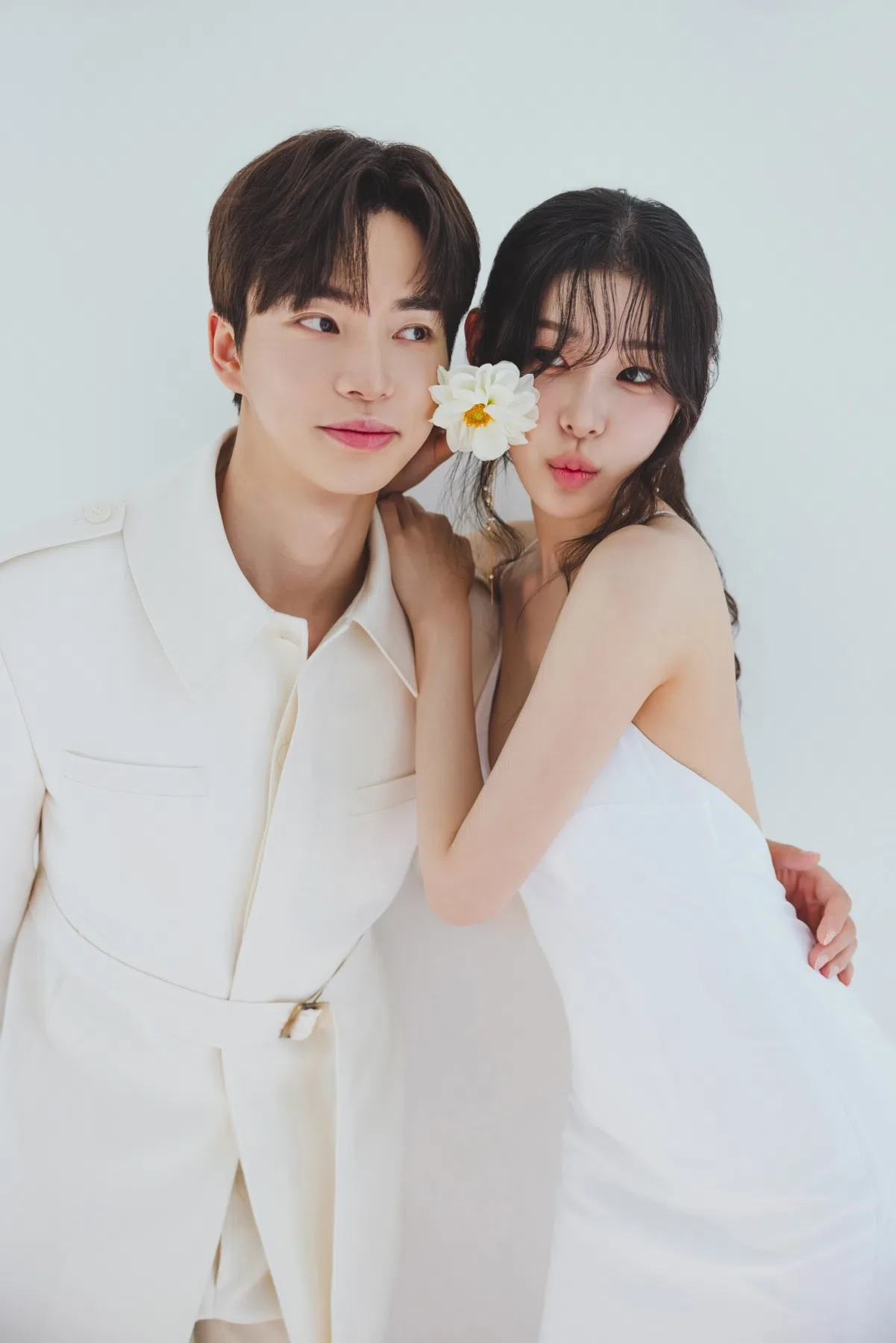 화이트 스튜디오의 자연광과 여백을 살린 커플 클로즈업입니다. 의상 실루엣과 표정 중심의 깨끗한 무드를 확인하기 좋습니다.