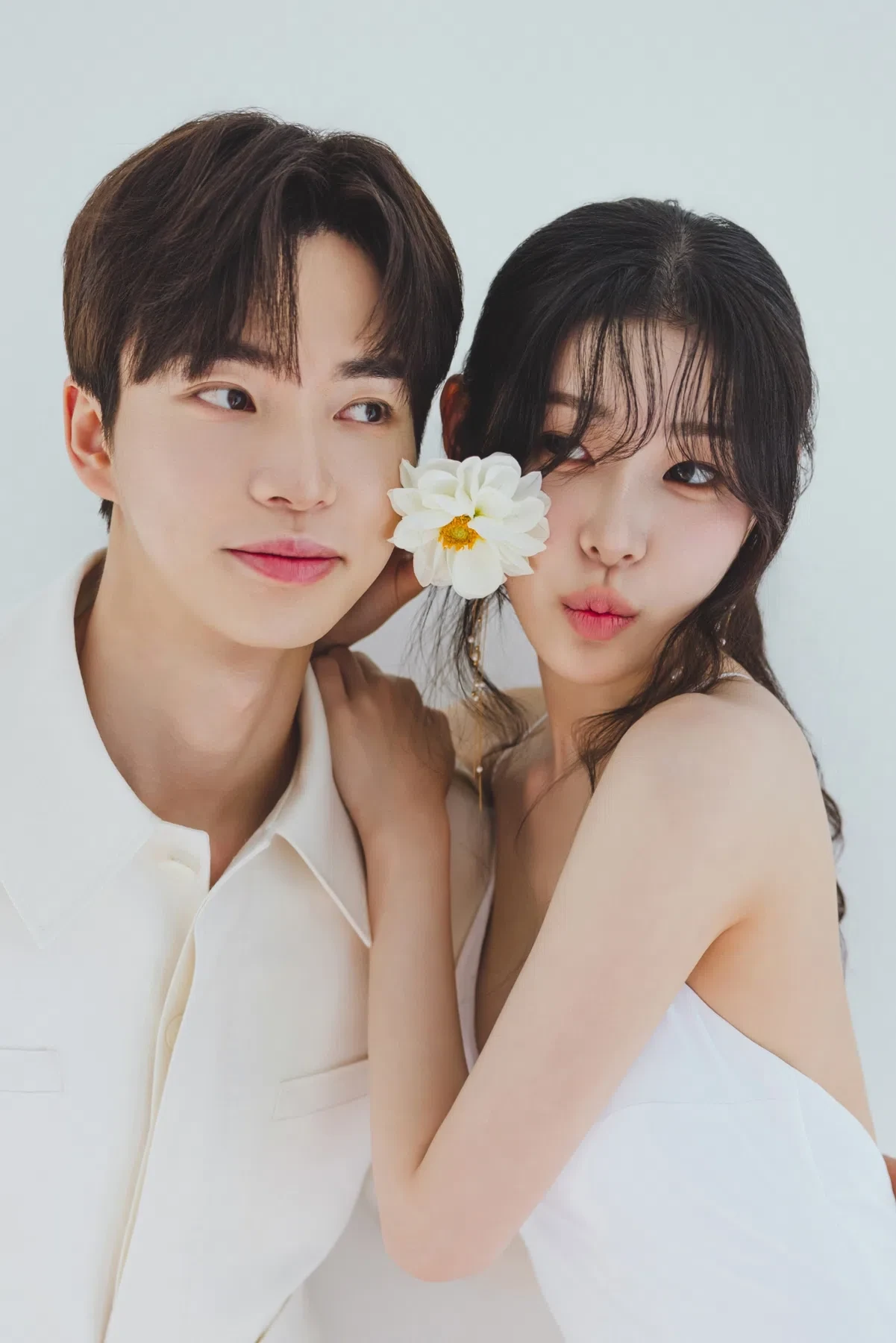 화이트 스튜디오의 자연광과 여백을 살린 커플 클로즈업입니다. 의상 실루엣과 표정 중심의 깨끗한 무드를 확인하기 좋습니다.