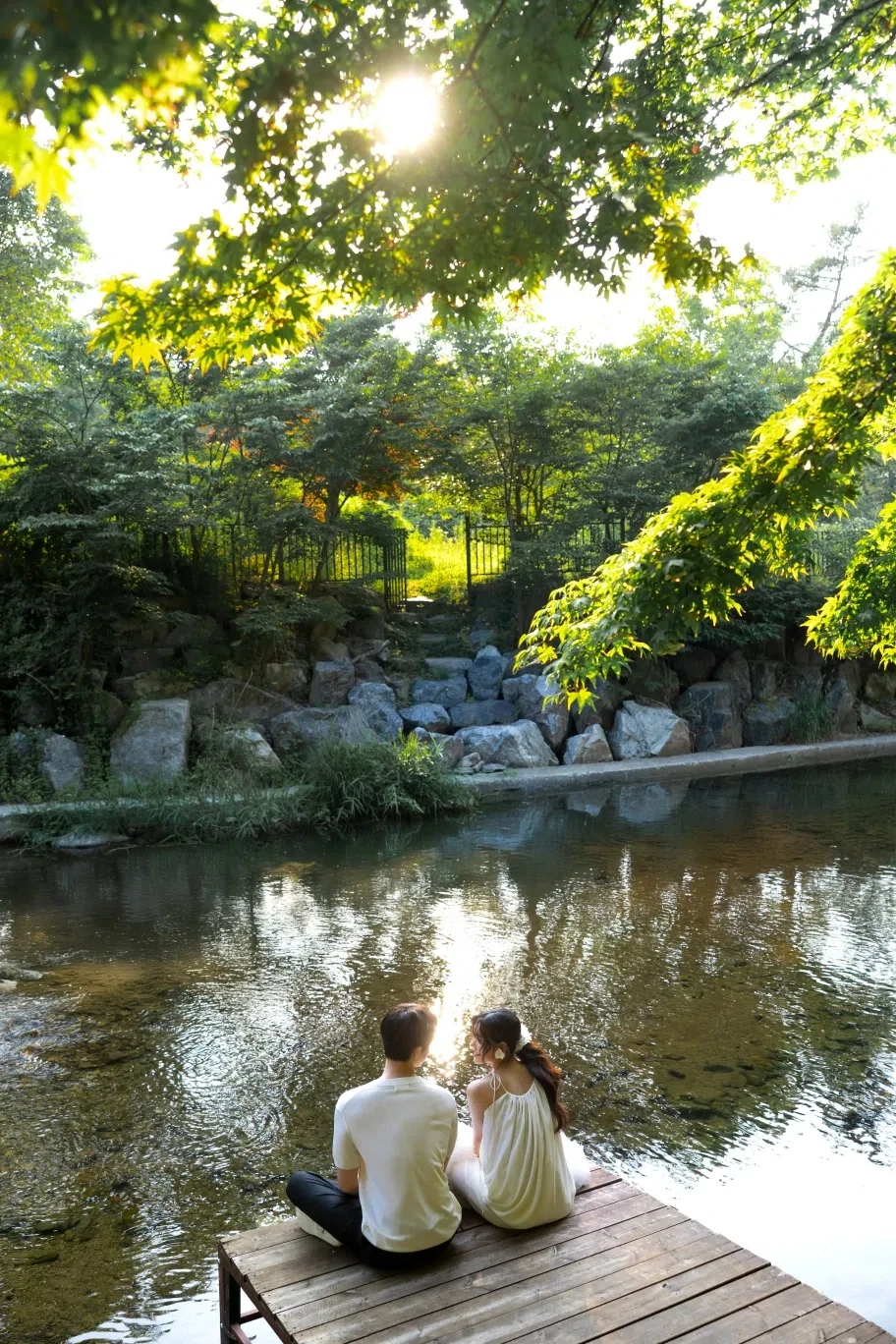 waterside deck의 계절감과 동선을 살린 라이프스타일 커플 컷입니다. 자연스러운 움직임과 초록 배경을 원하는 커플에게 어울립니다.