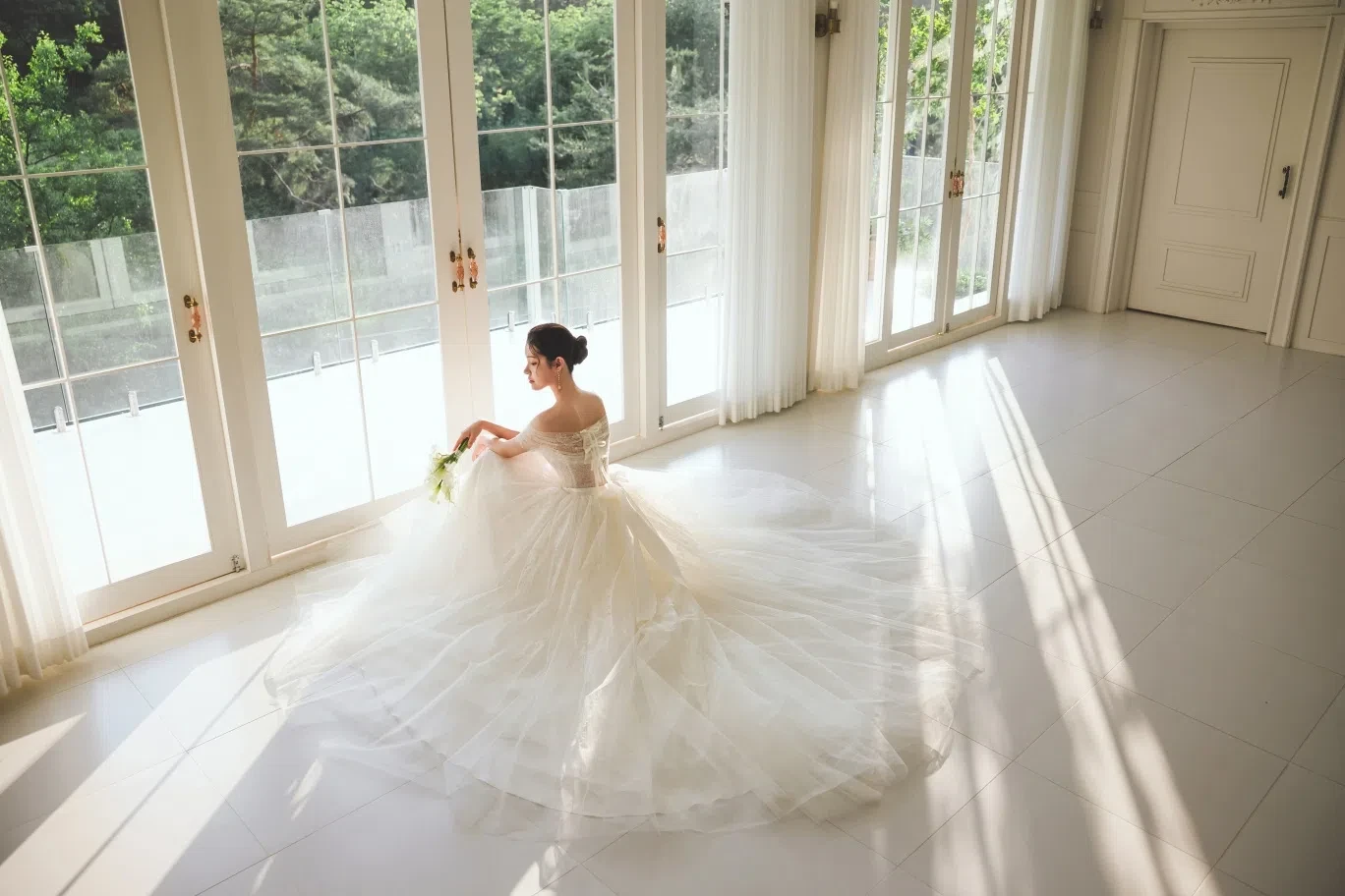 white window hall의 자연광과 여백을 살린 신부 단독 포트레이트입니다. 의상 실루엣과 표정 중심의 깨끗한 무드를 확인하기 좋습니다.