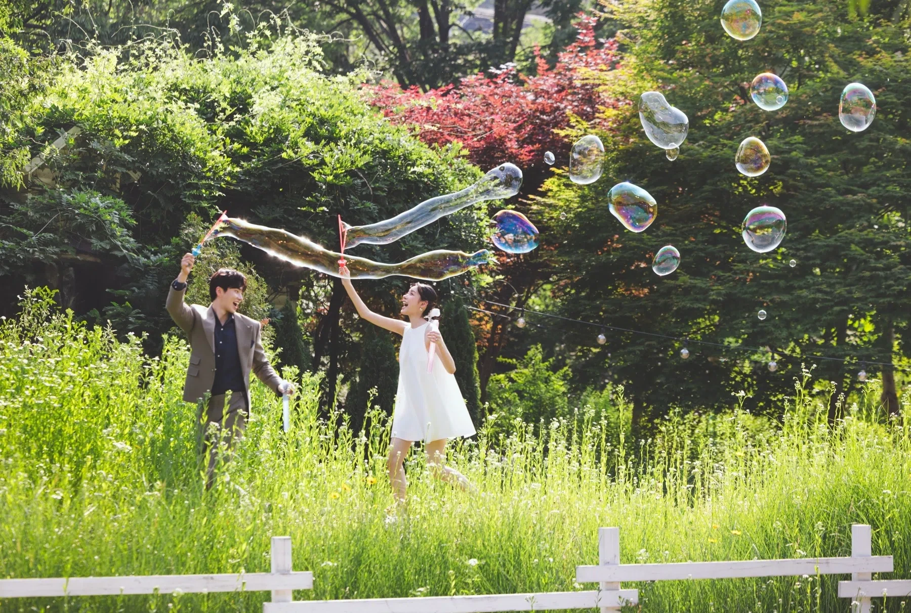 grass field의 계절감과 동선을 살린 경쾌한 연출 컷입니다. 자연스러운 움직임과 초록 배경을 원하는 커플에게 어울립니다.