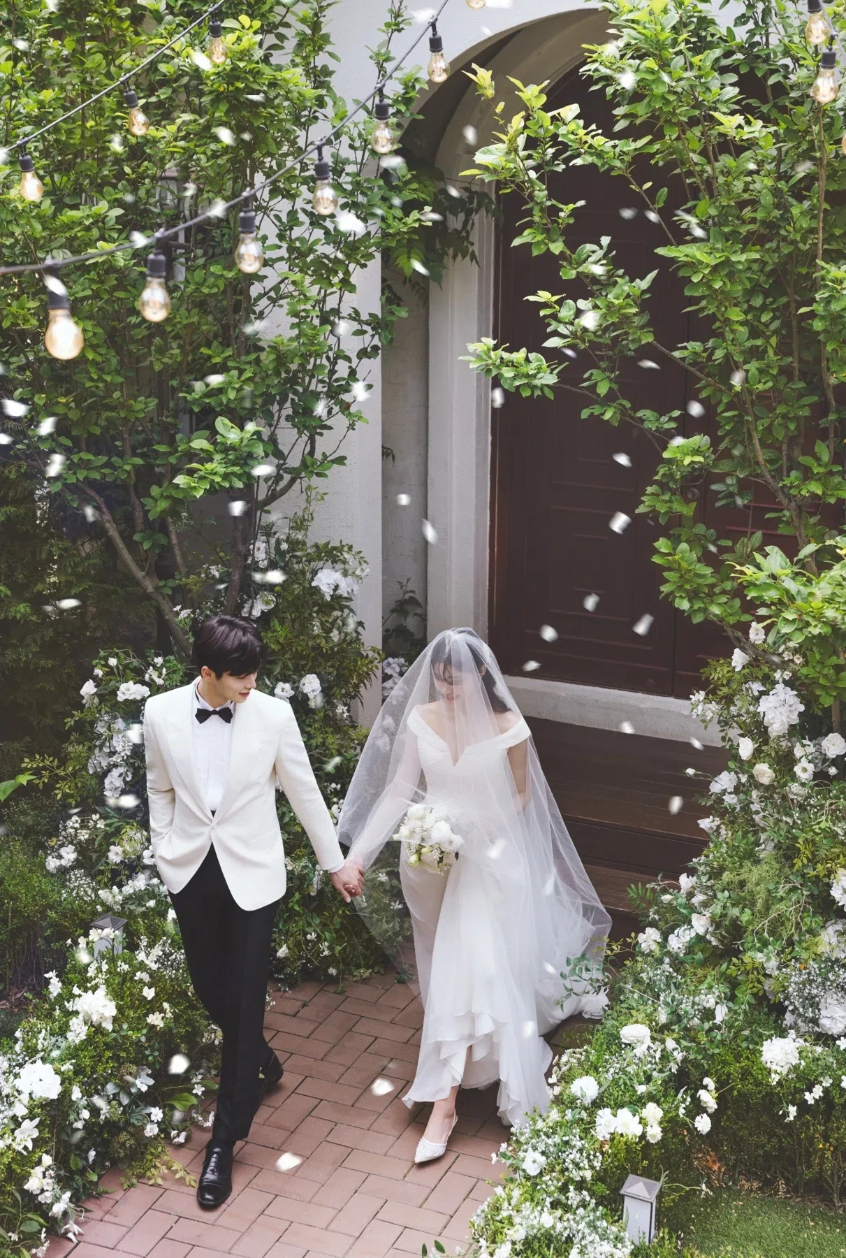 garden entrance의 계절감과 동선을 살린 포멀 커플 컷입니다. 자연스러운 움직임과 초록 배경을 원하는 커플에게 어울립니다.