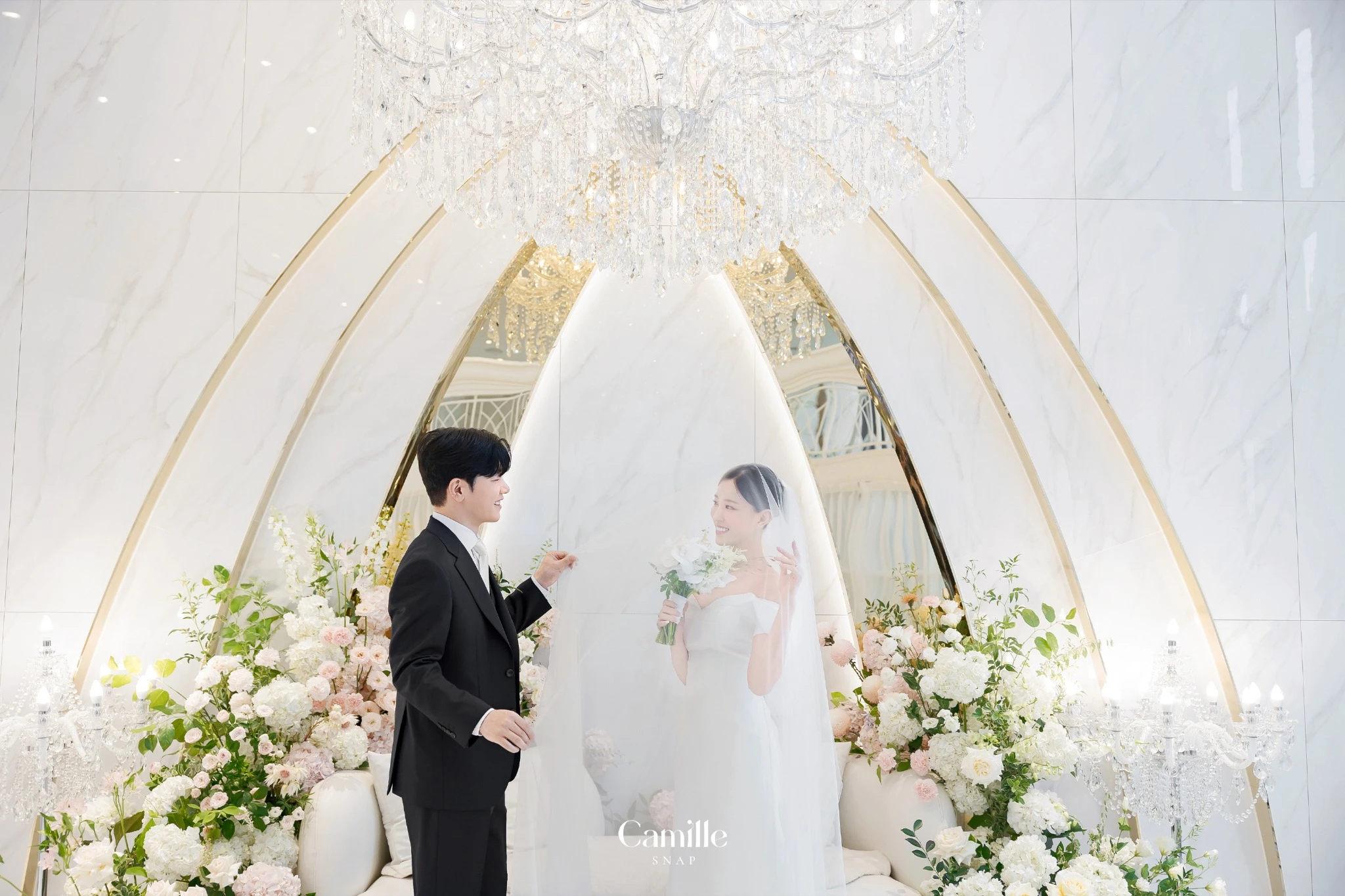 베일을 사이에 둔 신랑신부의 자연스러운 장면입니다.
