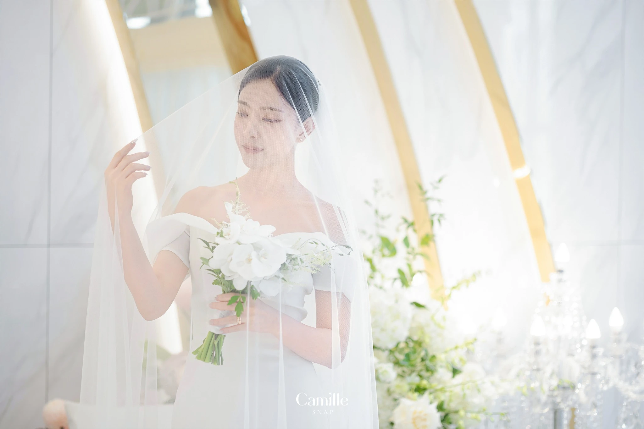 투명한 베일과 밝은 조명으로 부드럽게 표현된 신부 단독 컷입니다.