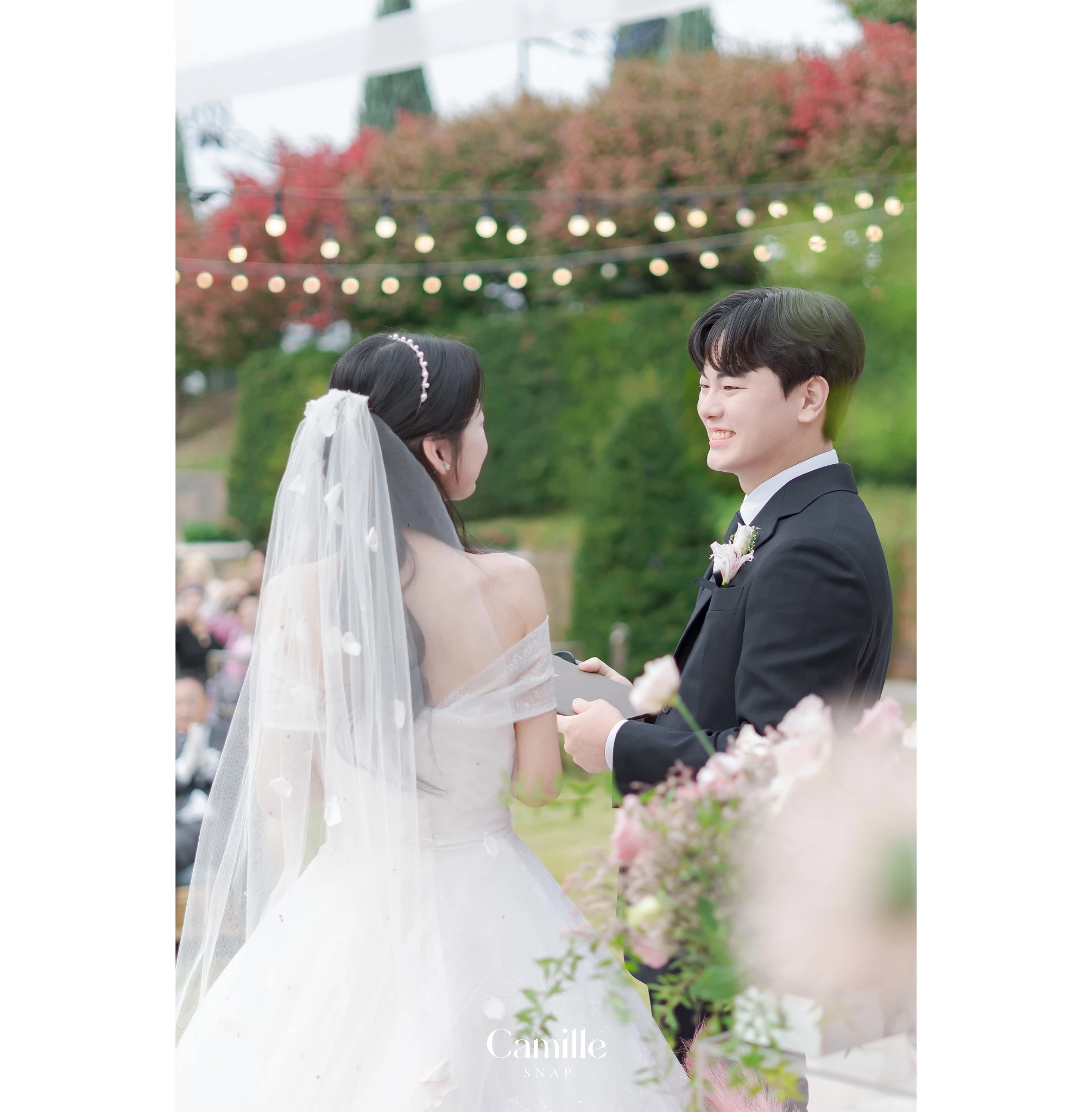 야외 예식 공간에서 신랑신부가 마주 선 차분한 본식 장면입니다.