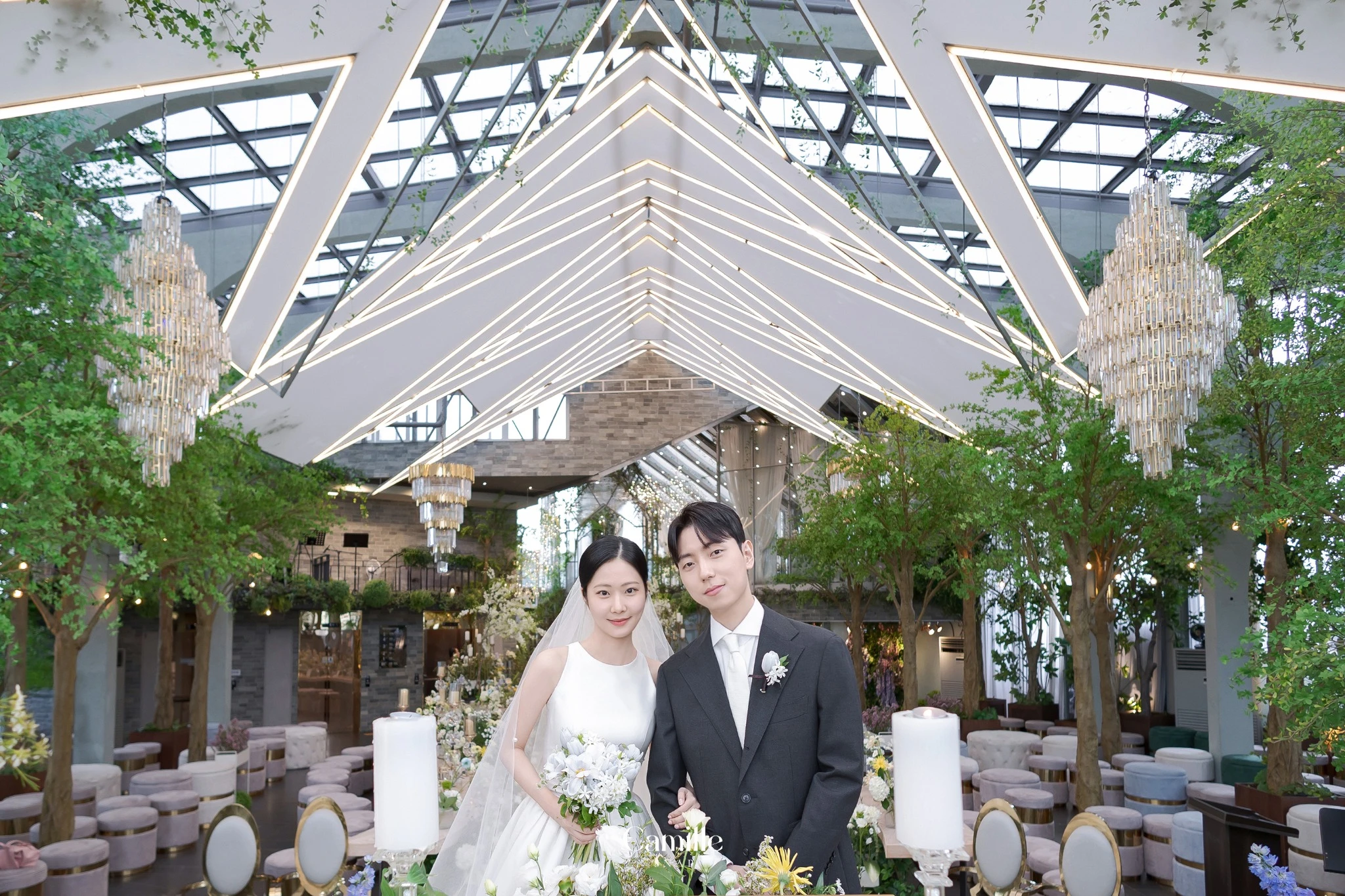 예식장 구조와 신랑신부가 함께 보이는 와이드 공간 컷입니다.