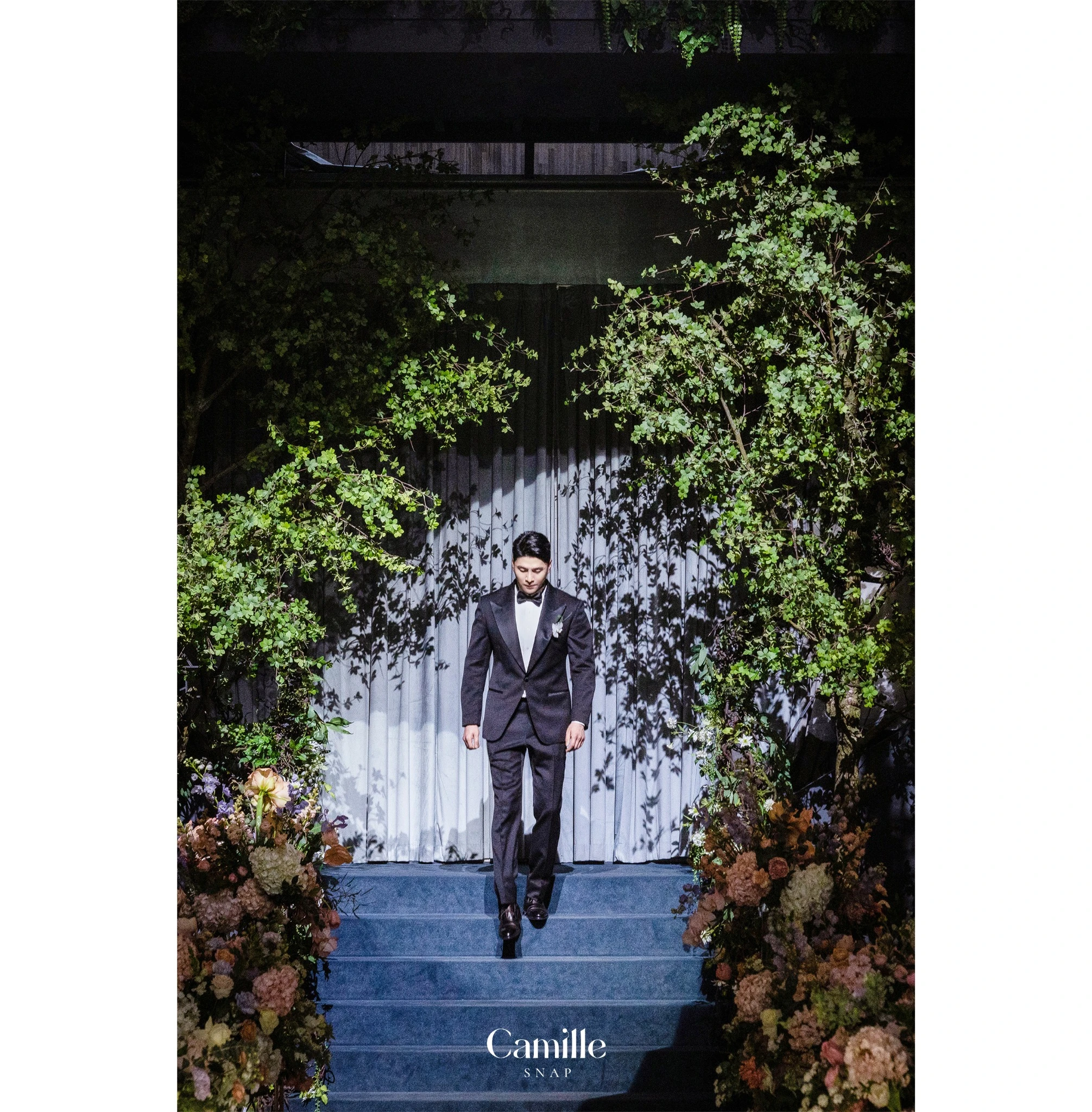 스포트라이트와 그림자가 신랑의 입장 장면을 강조하는 컷입니다.