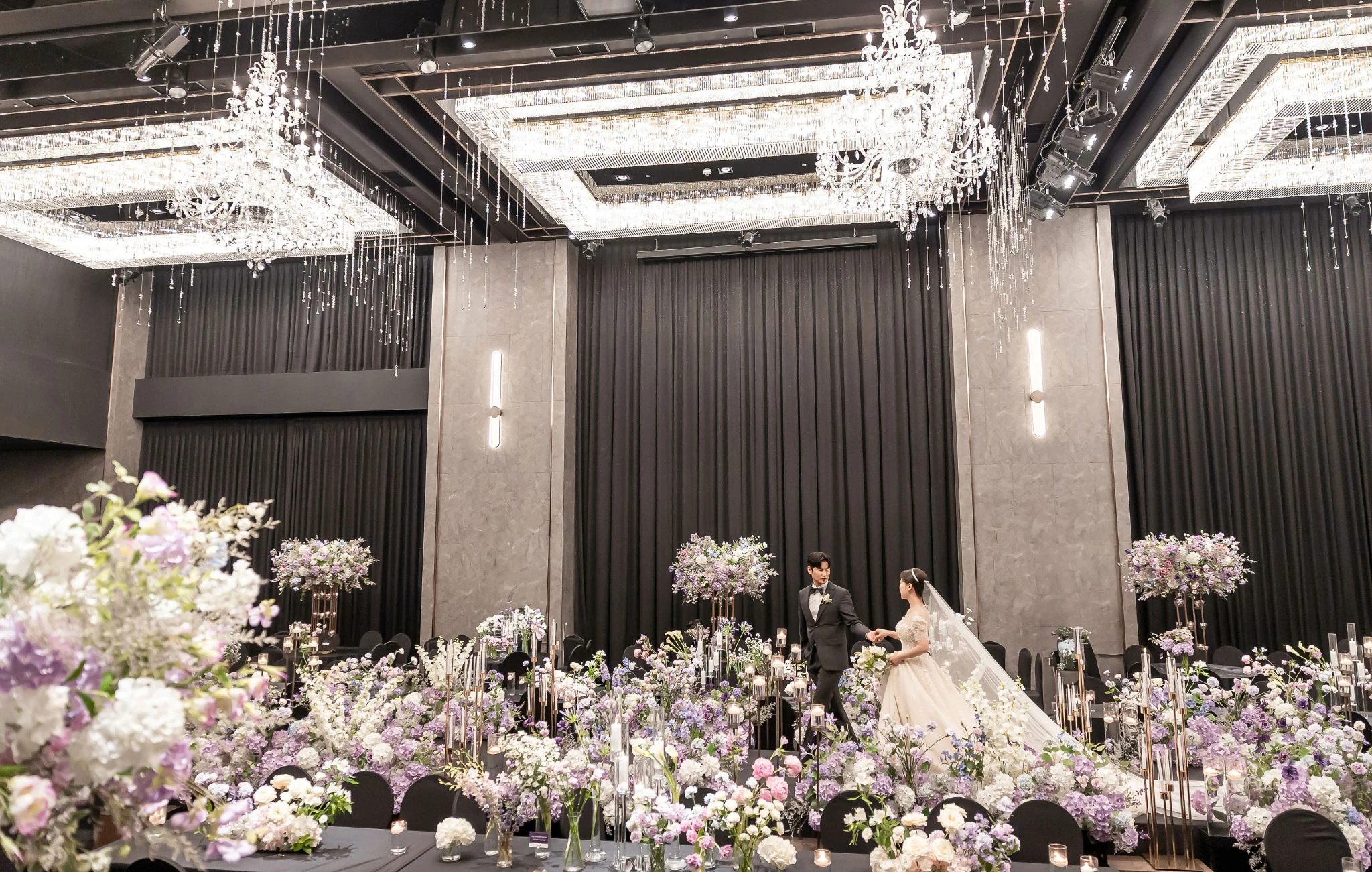 꽃 장식 클로즈 커플 컷으로, 꽃 장식 사이의 가까운 좌석 공간와 부케과 베일가 함께 보이는 장면입니다.