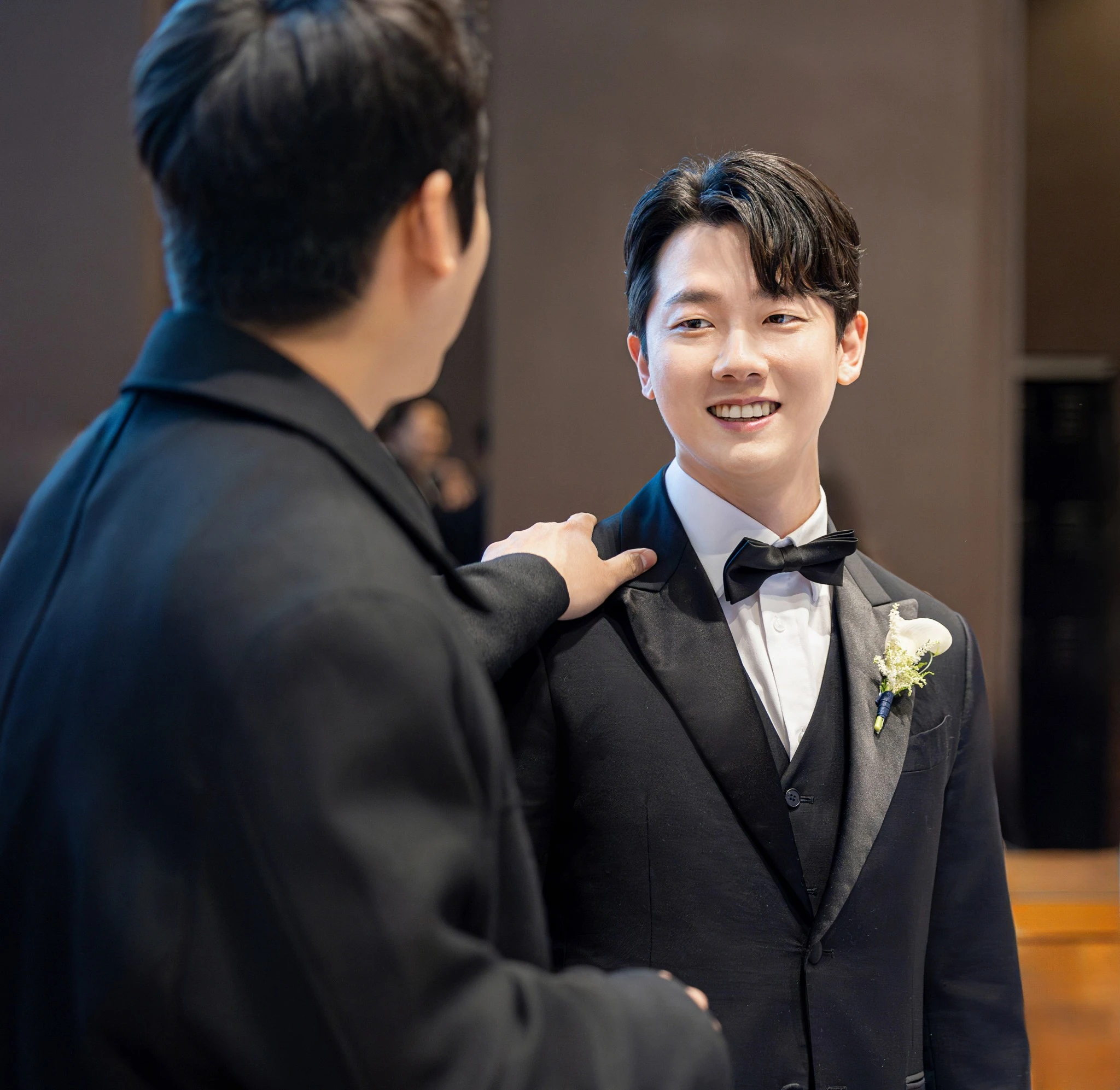 신부 단독 좌석 컷으로, 파스텔 꽃벽과 소파가 있는 실내와 소파과 부케가 함께 보이는 장면입니다.