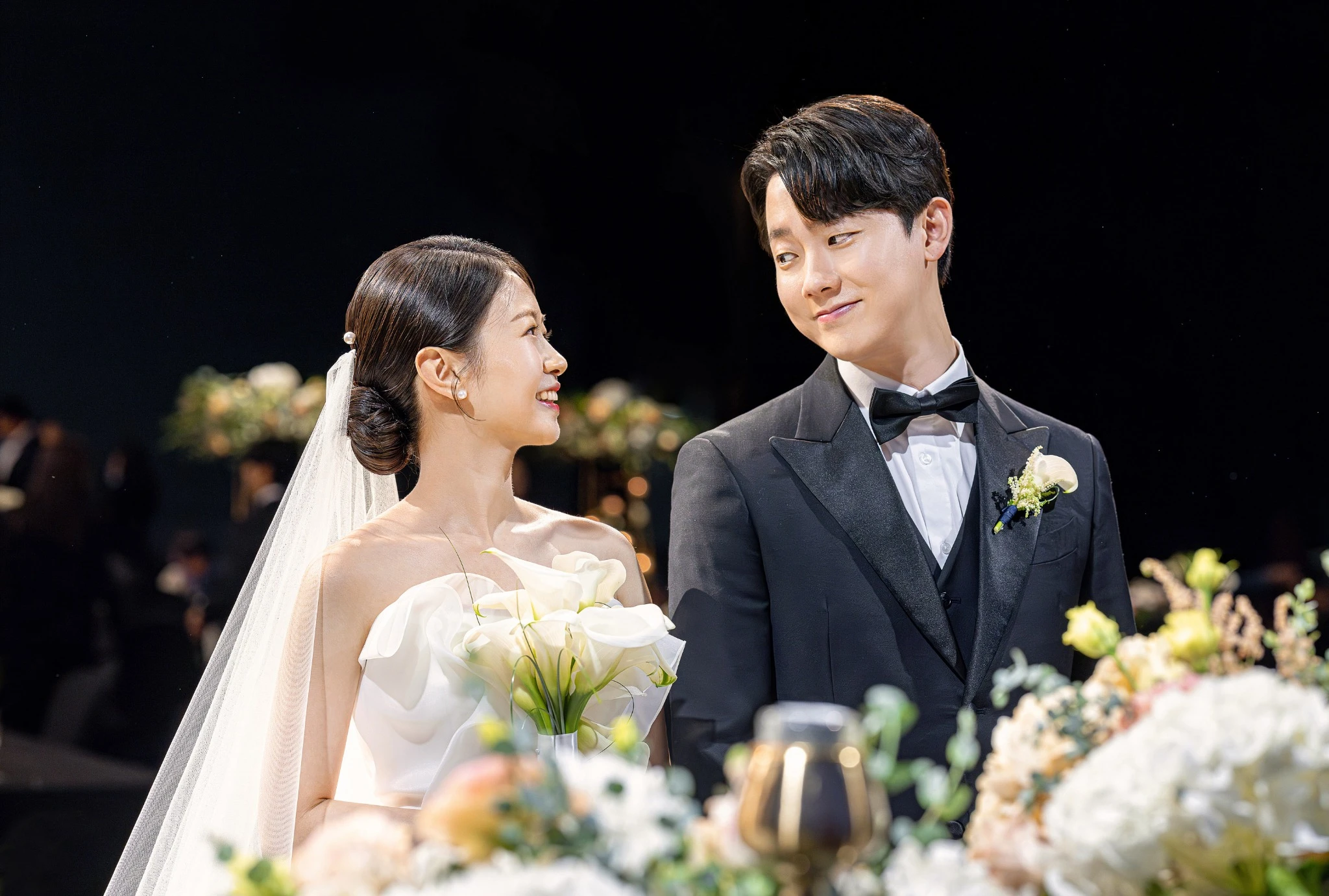 입장·행진 장면으로, 꽃과 촛불이 있는 어두운 버진로드와 버진로드과 촛불가 함께 보이는 장면입니다.