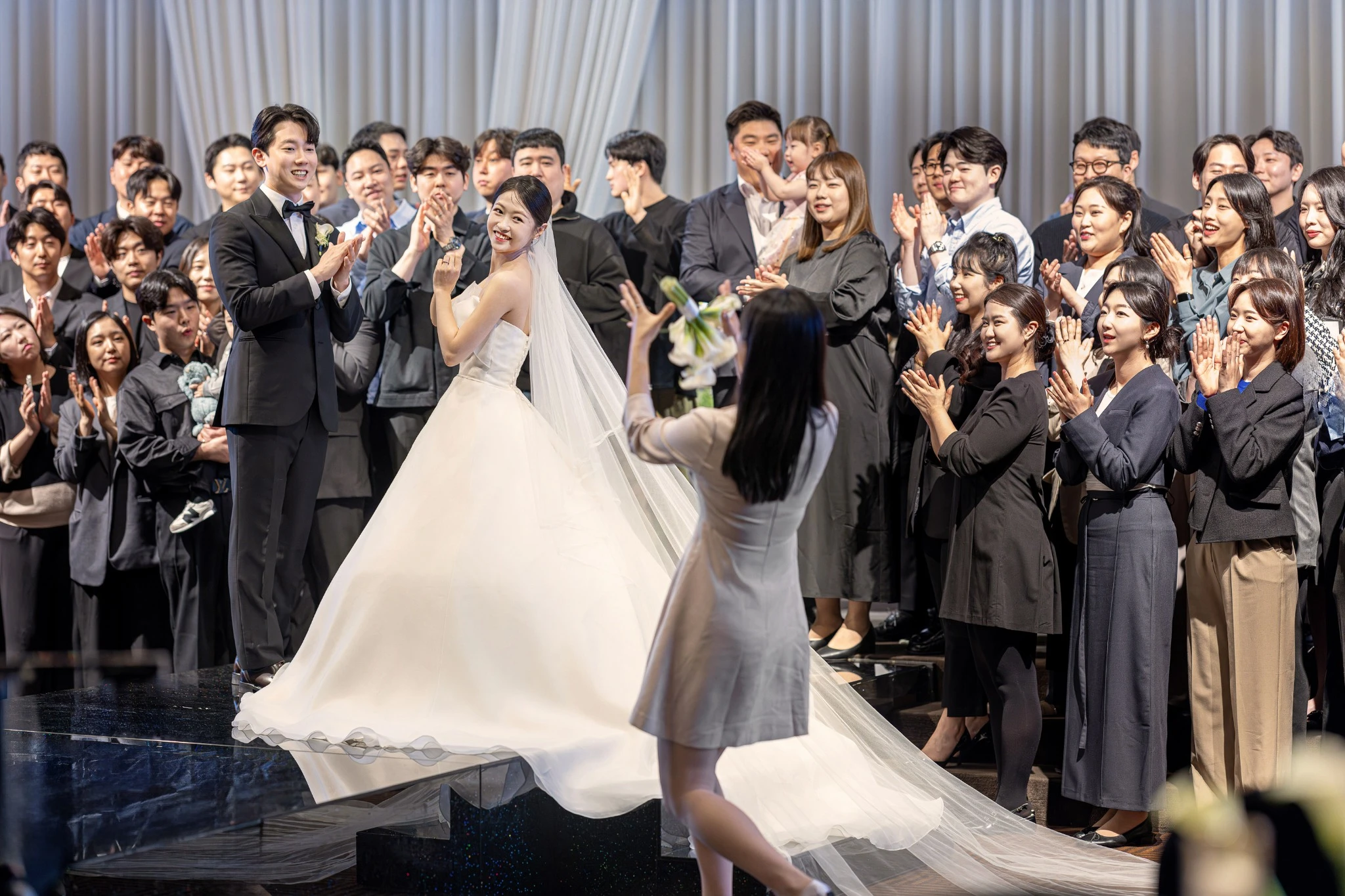 자연스러운 이동 장면으로, 꽃 장식과 촛대가 있는 실내 예식홀와 부케과 촛대가 함께 보이는 장면입니다.