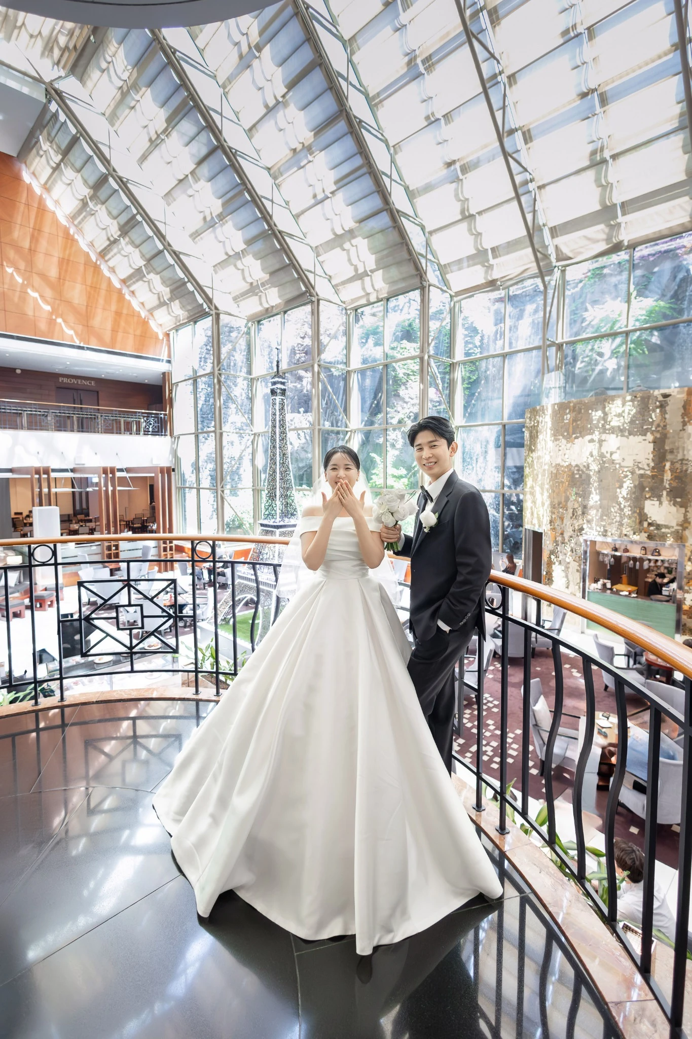신부 단독 클로즈업으로, 화이트와 파스텔 꽃 장식 앞와 부케과 티아라가 함께 보이는 장면입니다.