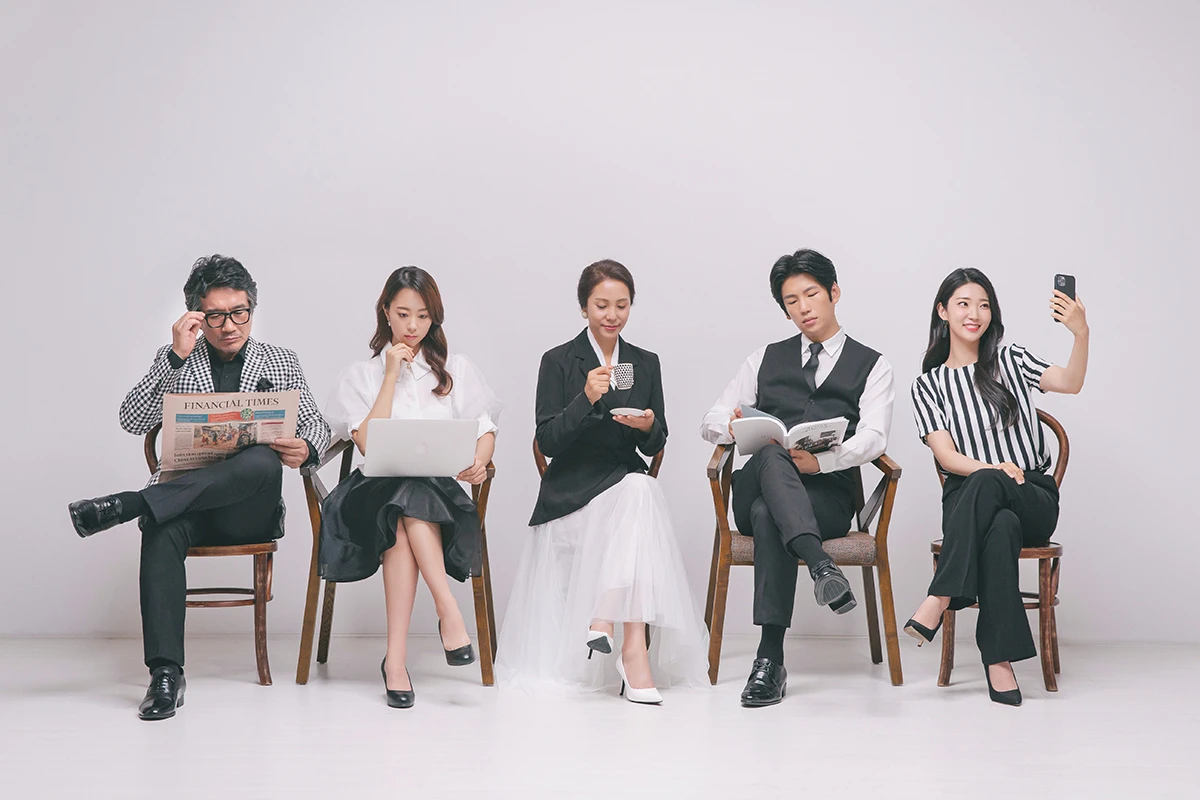 밝은 흰색 스튜디오 배경에서 성인 5명이 검정과 흰색 풍선을 들고 흰 배경 앞에 선 사진이며, 검정과 흰색 풍선가 장면의 구성을 보완합니다.